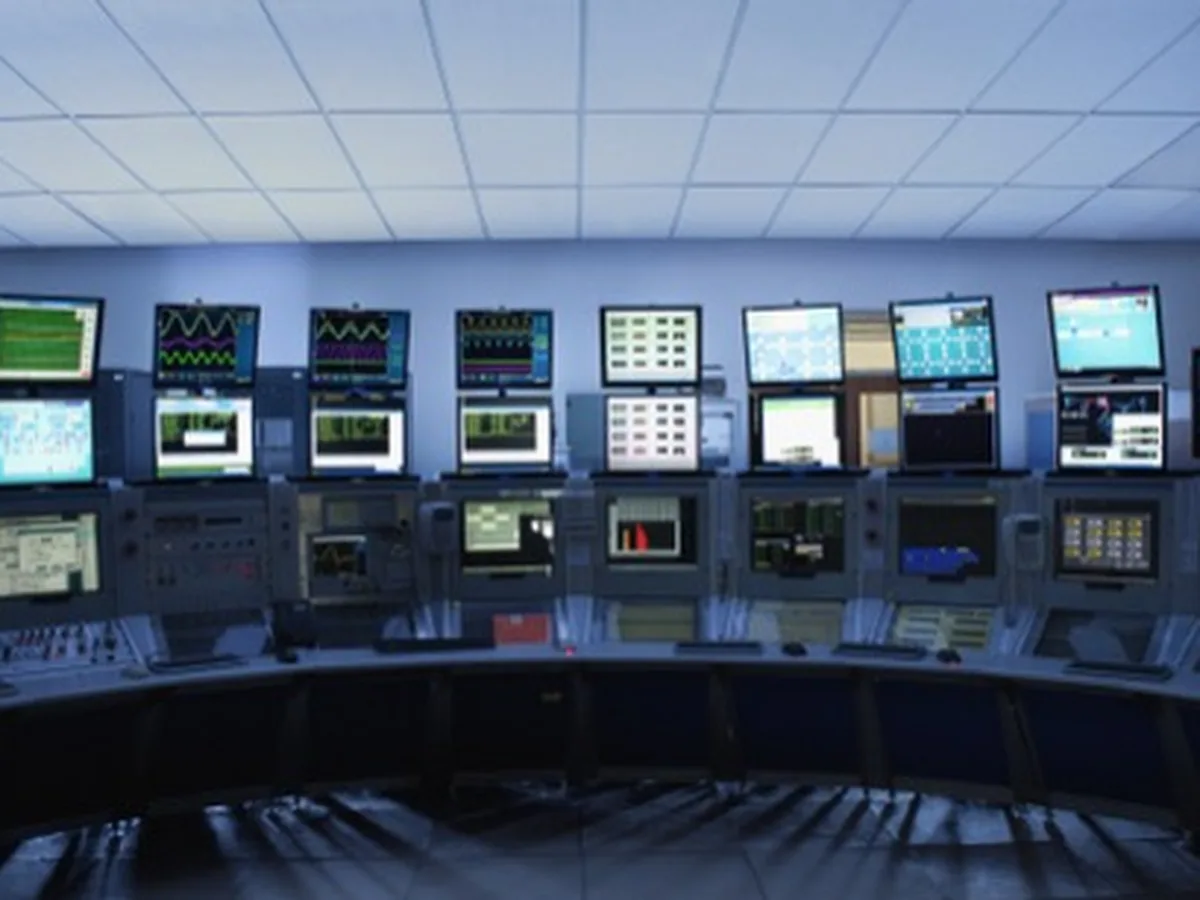 An empty control room with banks of monitoring screens.