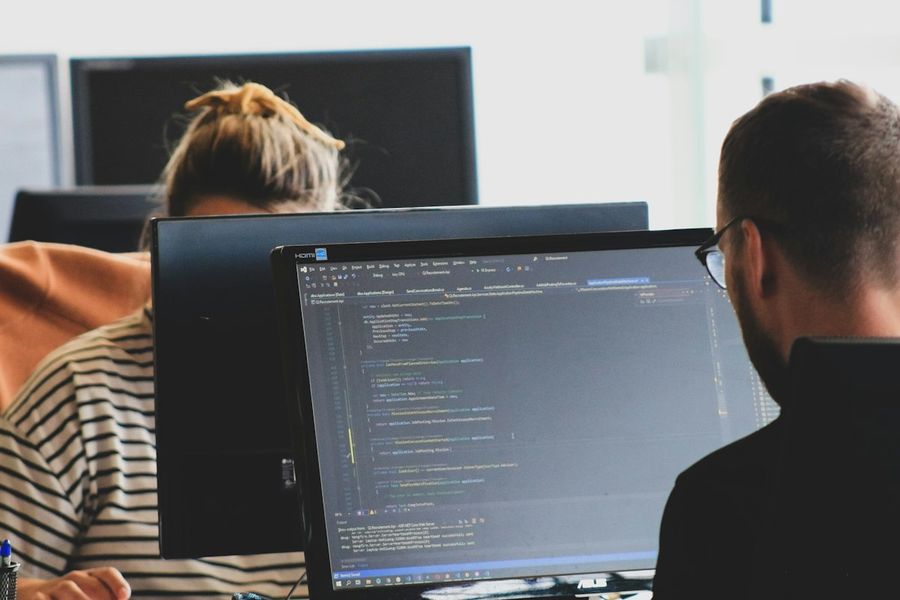 Two developers working on code at their monitors.